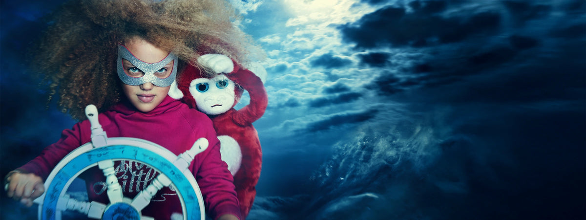 Ilvie Little dressed as a pirate at the helm with Captain Jack, sailing through a stormy ocean.