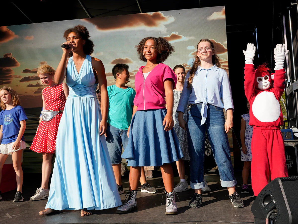 Children and performers on stage during an Ilvie Little & Friends live musical experience.